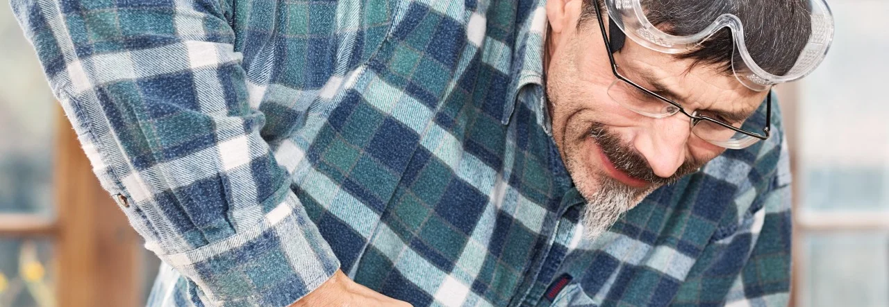 Person befestigt Metallteil mit Nietzange