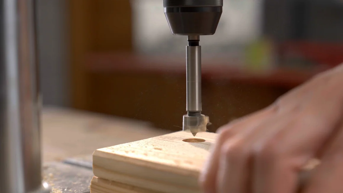 Bohrer bohrt Loch in Holzbrett