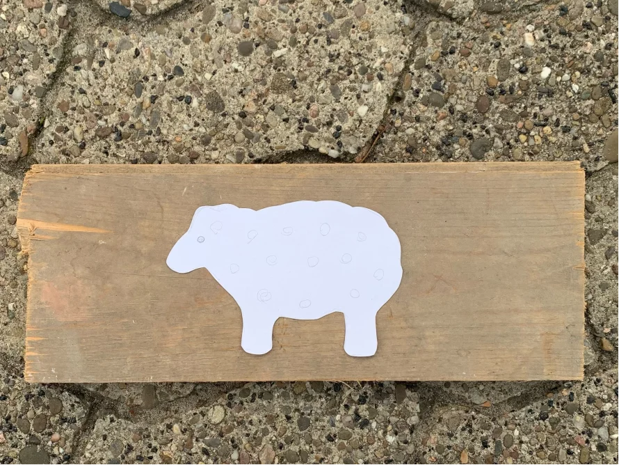 Schablone eines Schafs aus Papier auf Holz