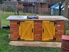 Außenküche aus Backstein mit Holztüren