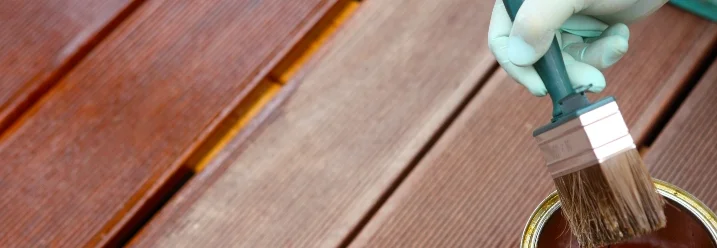 Hand trägt streicht Terrasse mit Pinsel