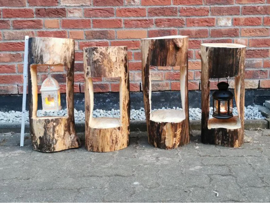 Vier Baumstammstümpfe mit Laternen