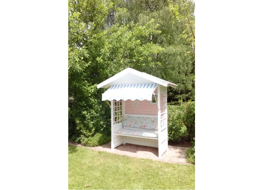 Rosafarbene Gartenlaube mit Bank