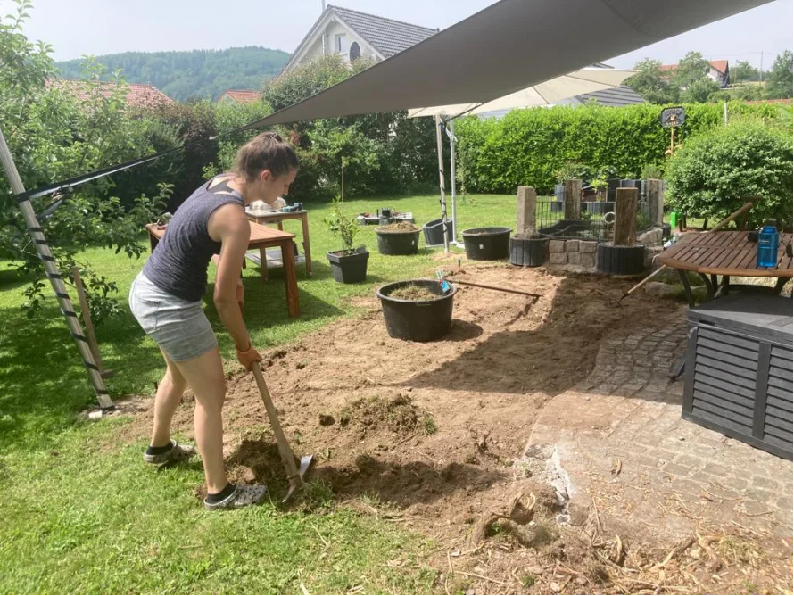 Person gräbt mit Spaten Erde um