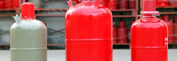 Drei Gasflaschen in rot und grau.