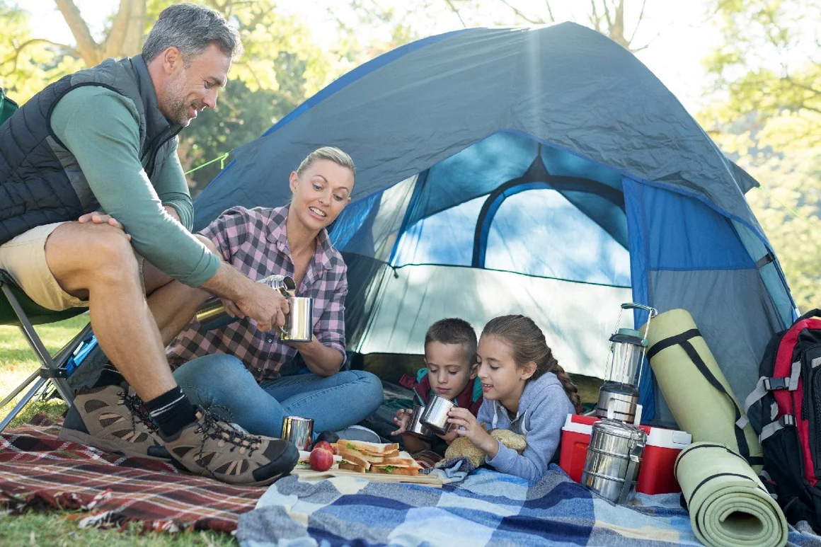 Familie beim Camping frühstückt vor Zelt