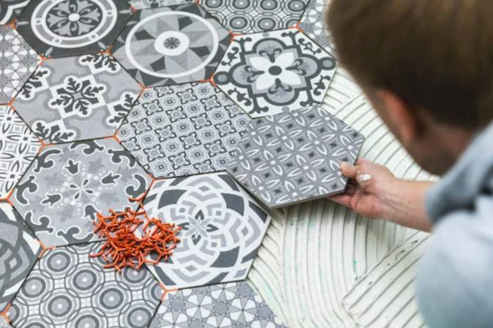 Person verlegt sechseckige Fliesen