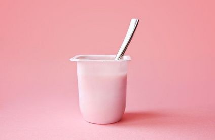 Thermomere Joghurtbecher vor rosafarbenen Hintergrund