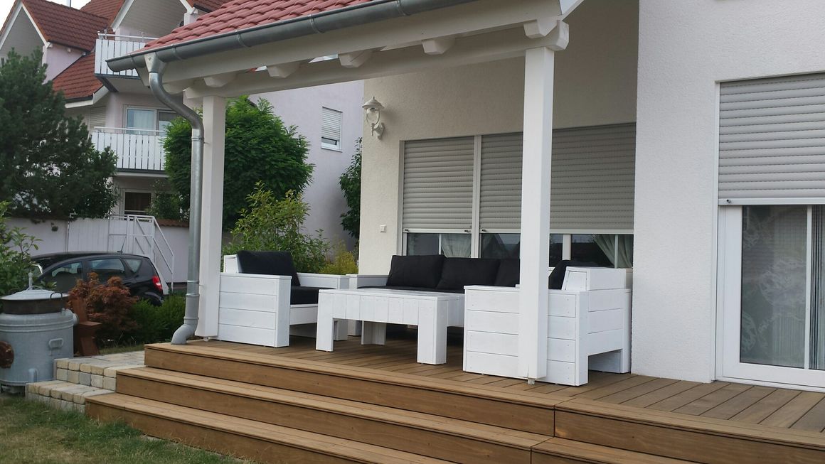 Weiße Gartenmöbel auf Holzterrasse