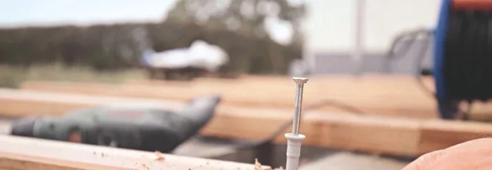 Person verschraubt Holzbalken