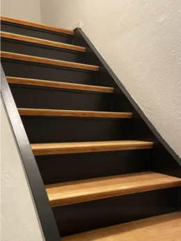 Moderne Holztreppe mit schwarzen Stufen