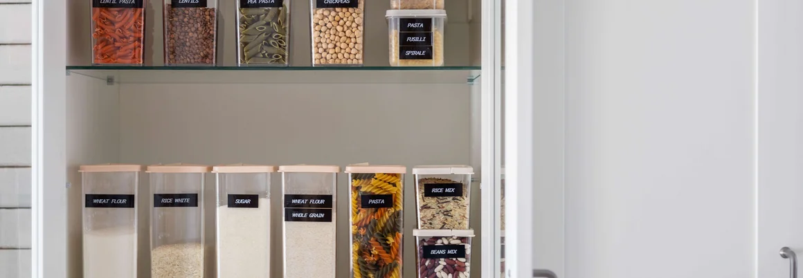 Ein offener Küchenschrank mit Gläsern voller Lebensmittel.