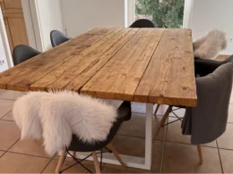 Holztisch mit Stühlen und Fellen