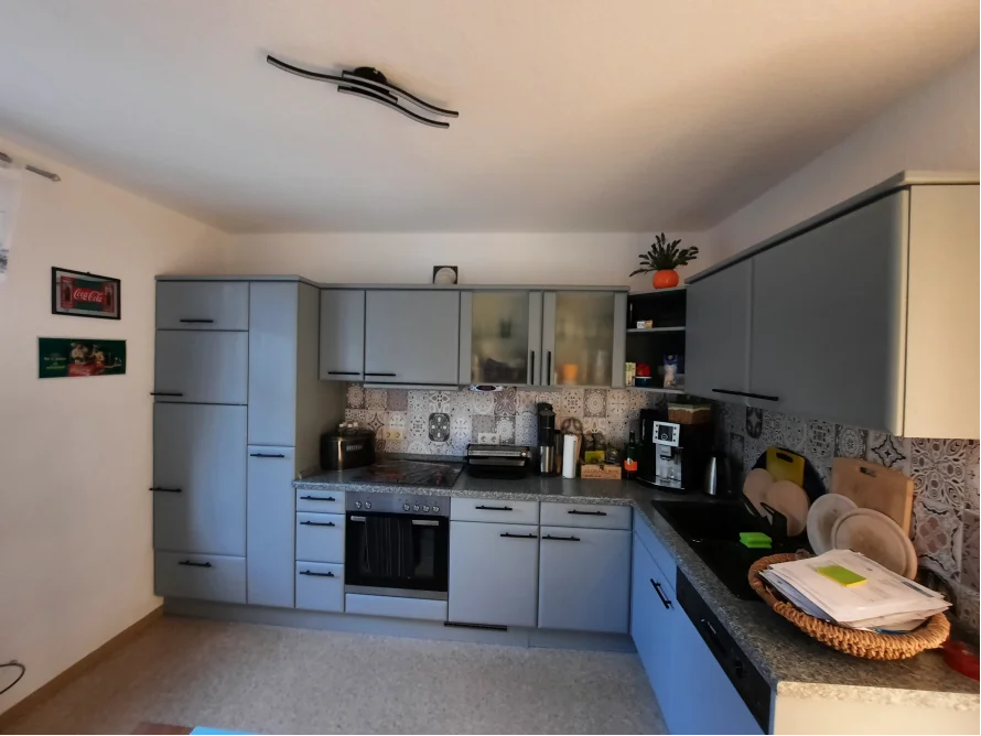 Moderne Küche in Grau mit schwarzen Griffen