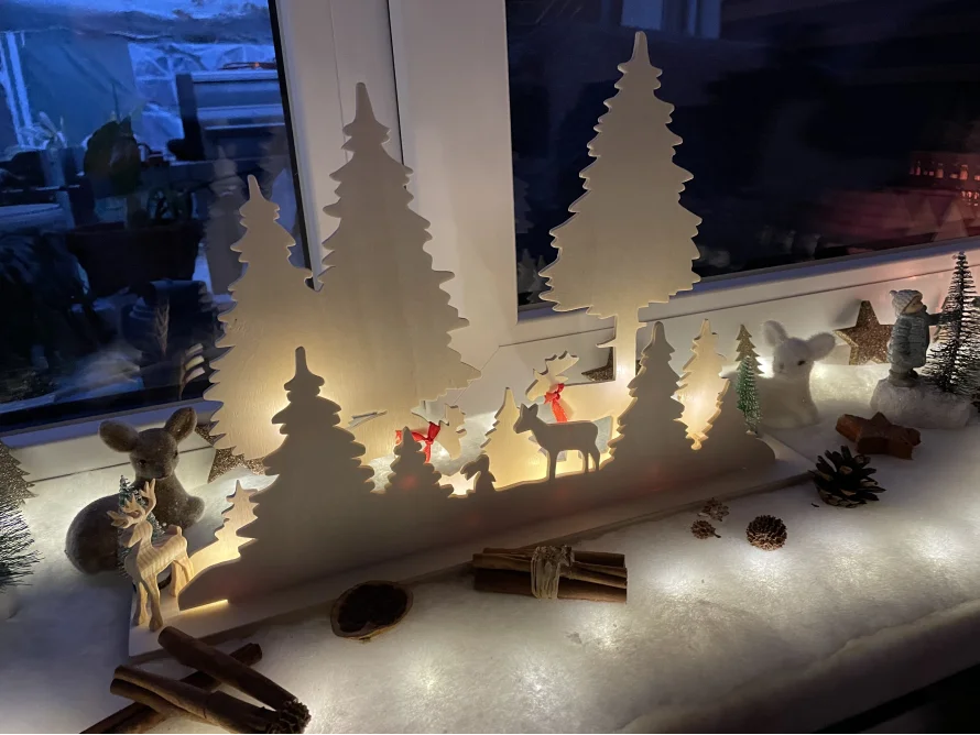 Beleuchtete Holzdekoration mit Wald und Rehen