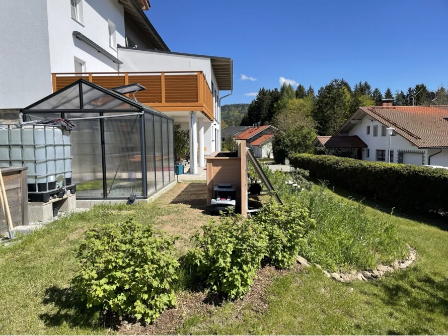 Garten mit Gewächshaus und Hochbeet