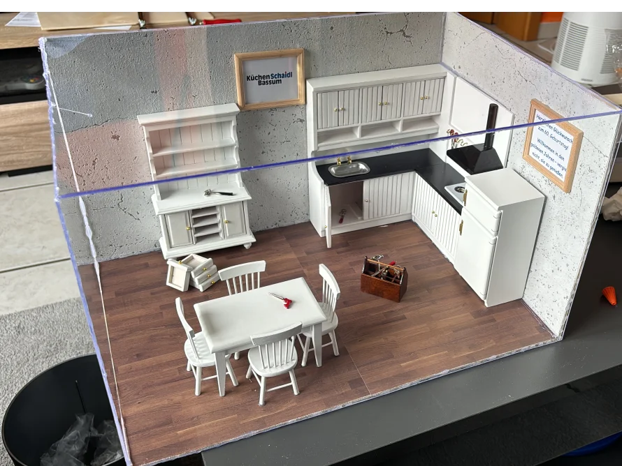 Modell einer weißen Küche mit Esstisch und Werkzeugkiste