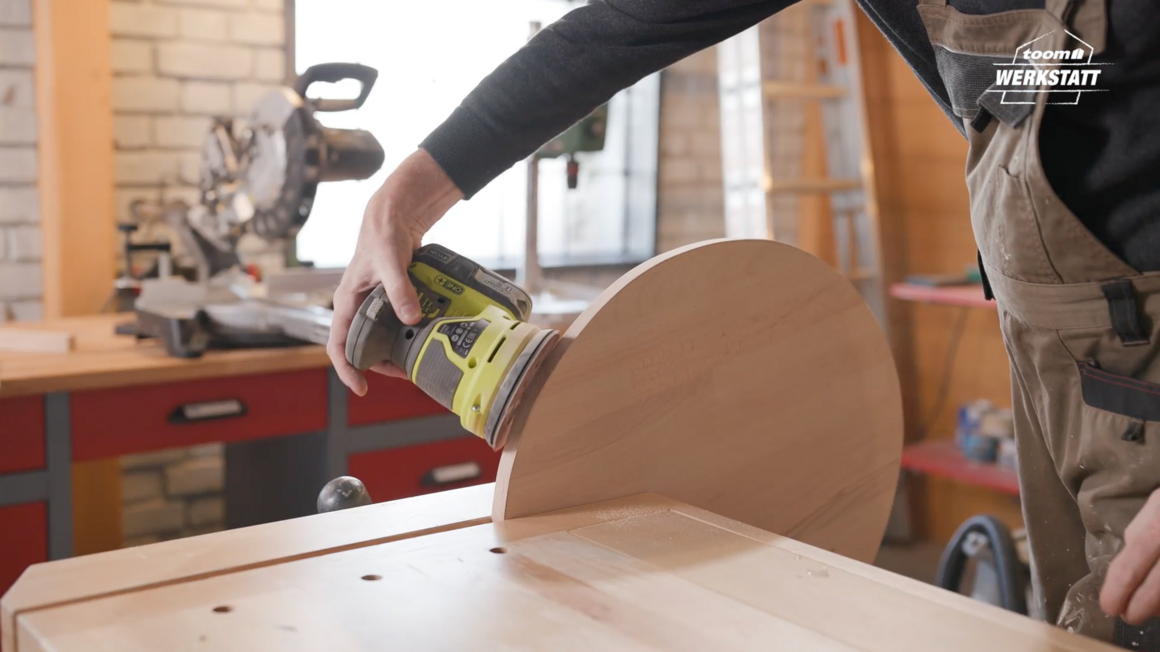 Person schleift eine Holzplatte