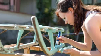 Person streicht einen Schlitten mit Pinsel