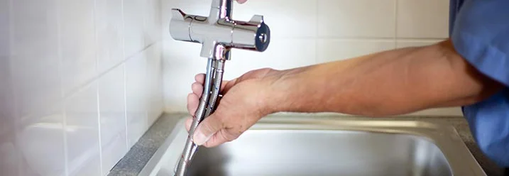 Person montiert Wasserhahn