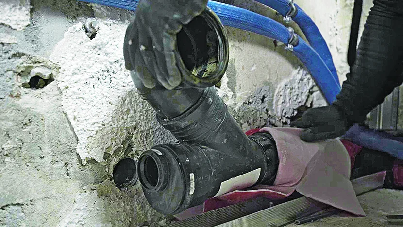 Person beim Verlegen von Abwasserrohren