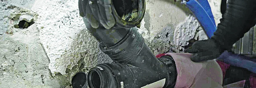 Person beim Verlegen von Abwasserrohren