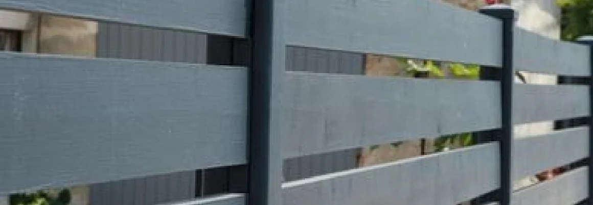 Ein grauer Holzzaun mit horizontalen Latten.