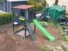 Spielplatz im Garten mit Spielhaus, Schaukel und Rutsche