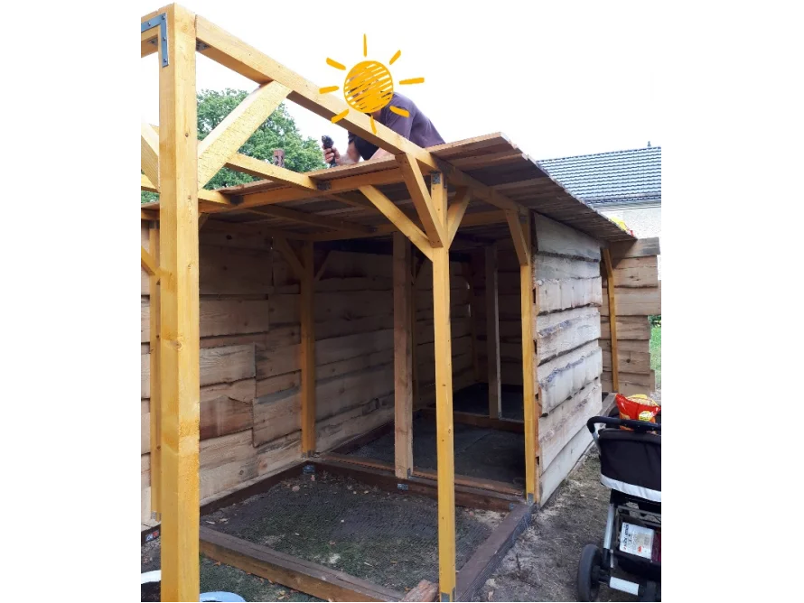 Person baut ein Gartenhaus aus Holz
