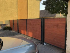 Ein moderner Holzzaun mit schwarzen Metallrahmen