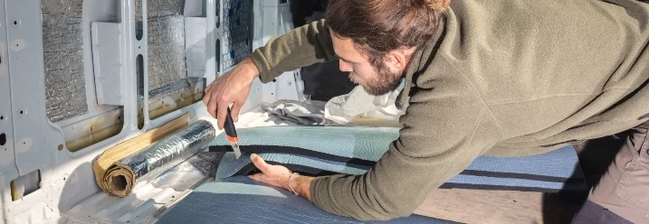 Person schneidet Dämmmaterial mit Cuttermesser zu.