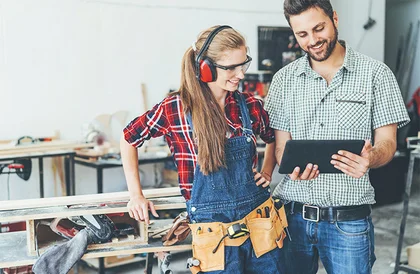 Zwei Personen betrachten Tablet in Werkstatt