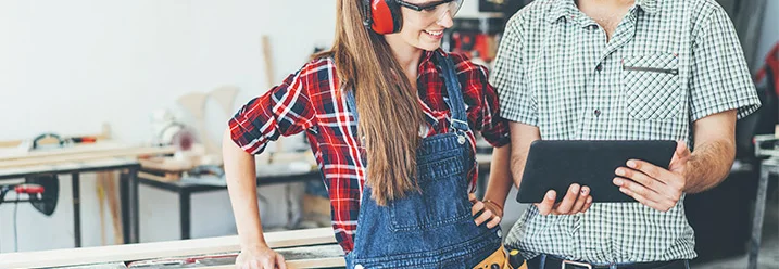 Zwei Personen betrachten Tablet in Werkstatt