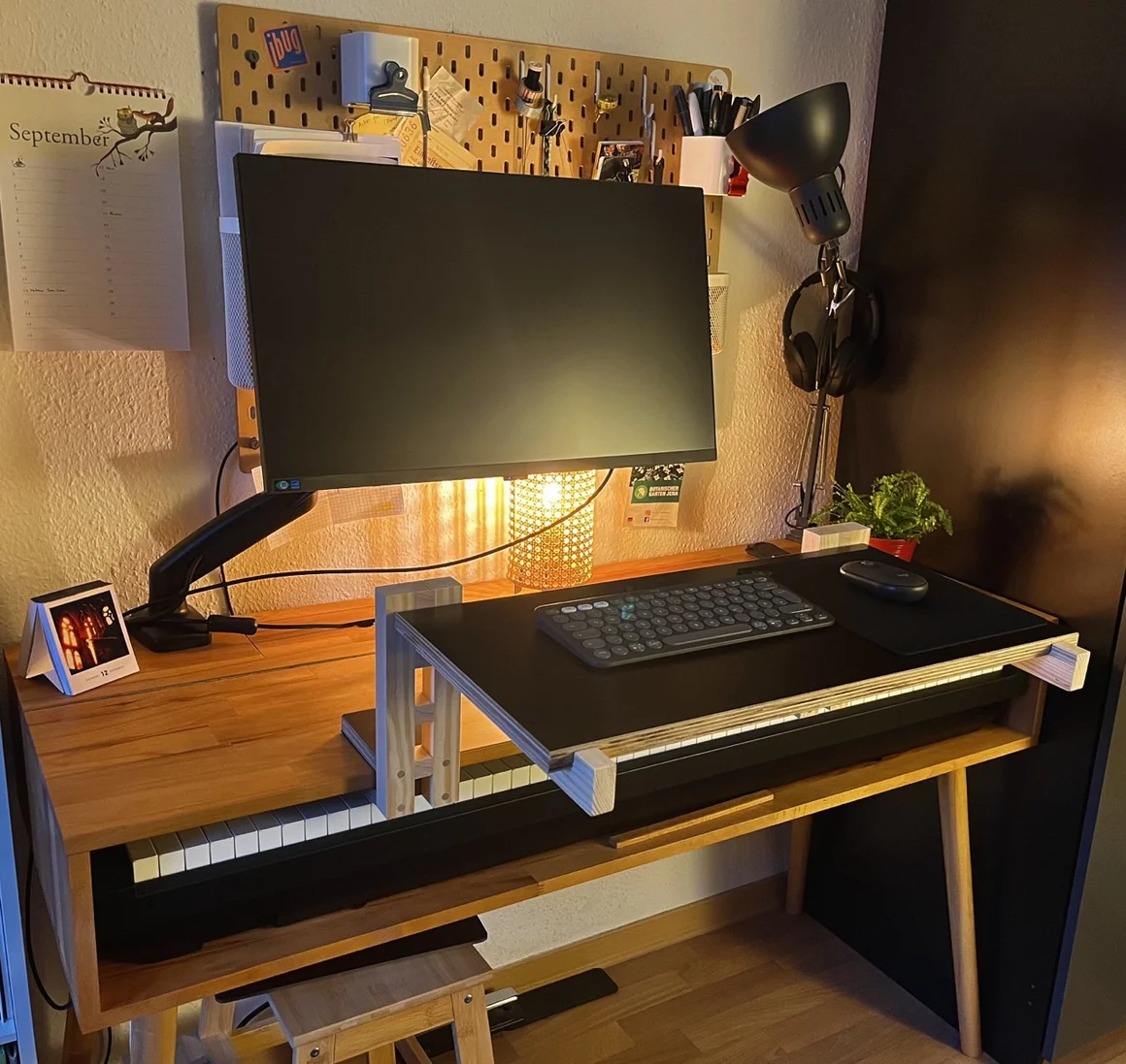 Ein Schreibtisch mit Computer und integriertem E-Piano.