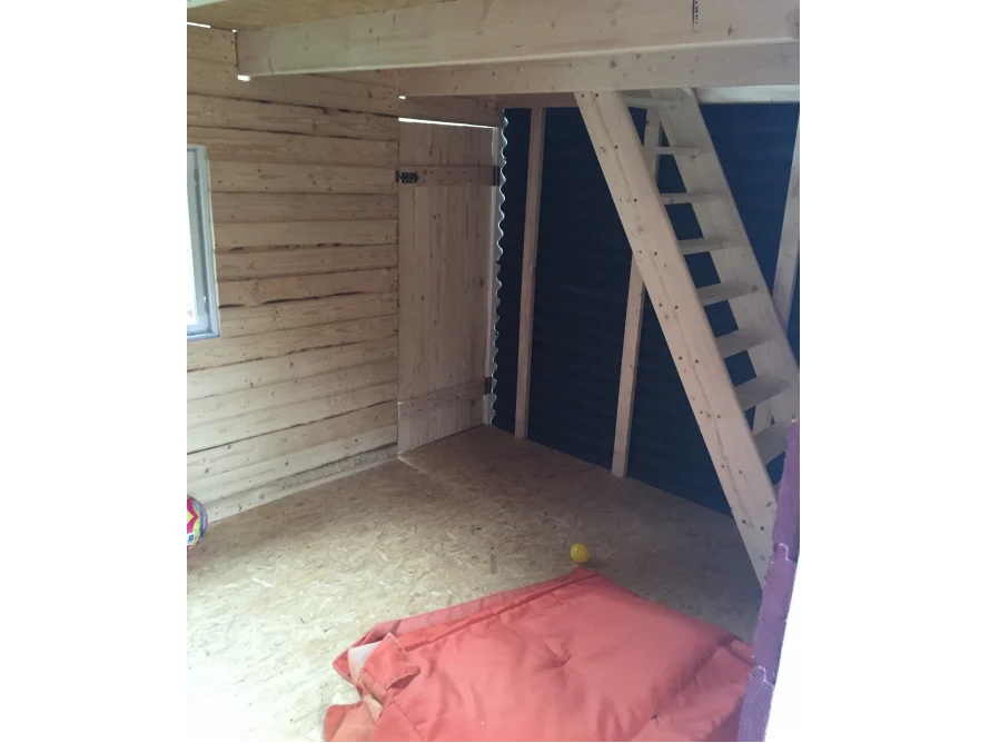 Innenansicht eines Gartenhauses mit Holztreppe