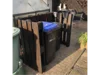 Mülltonnenverkleidung aus dunklem Holz