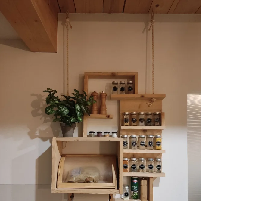 Hängeregal aus Holz mit Gewürzen und Brotdose