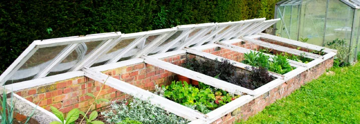Frühbeet aus Ziegelsteinen mit aufklappbaren Fenstern