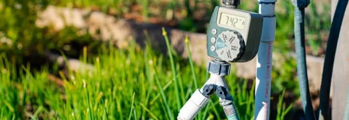 Bewässerungscomputer an einem Wasserhahn im Garten