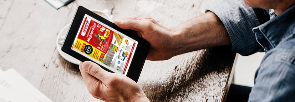 Eine Person hält ein Tablet, das die Angebote der Folgewoche anzeigt