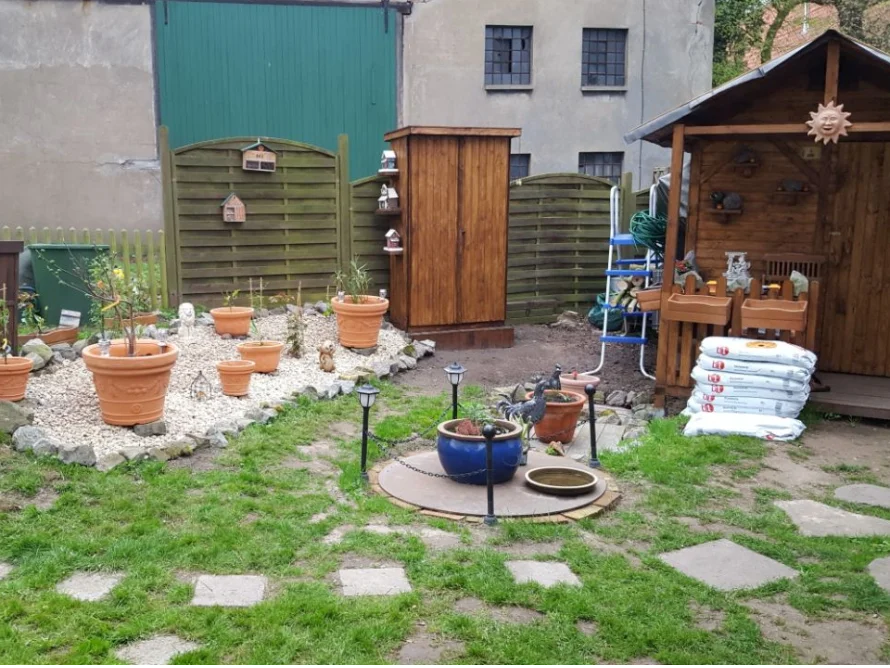 Garten mit Gartenhaus und Blumentöpfen