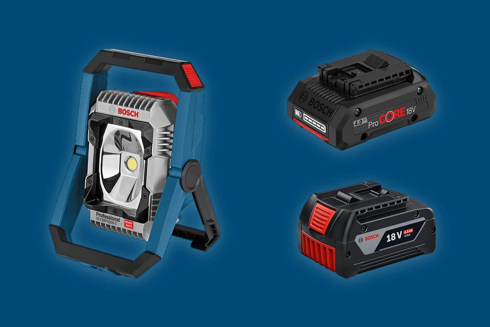 Zwei Bosch Akkupacks und eine Akku-Bauleuchte auf blauem Hintergrund