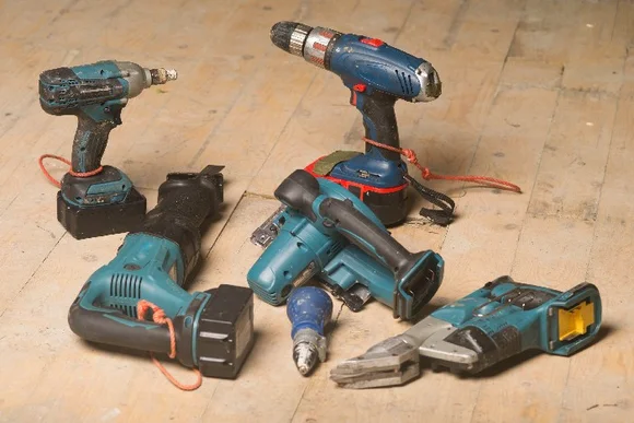 Sechs Elektrowerkzeuge auf Holzboden