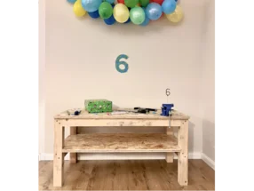 Geburtstagsdeko mit Schraubstock auf Tisch