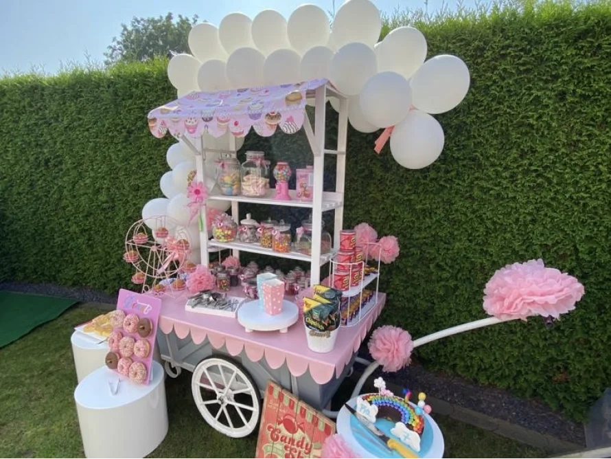 Süßer rosa Süßigkeitenwagen im Freien