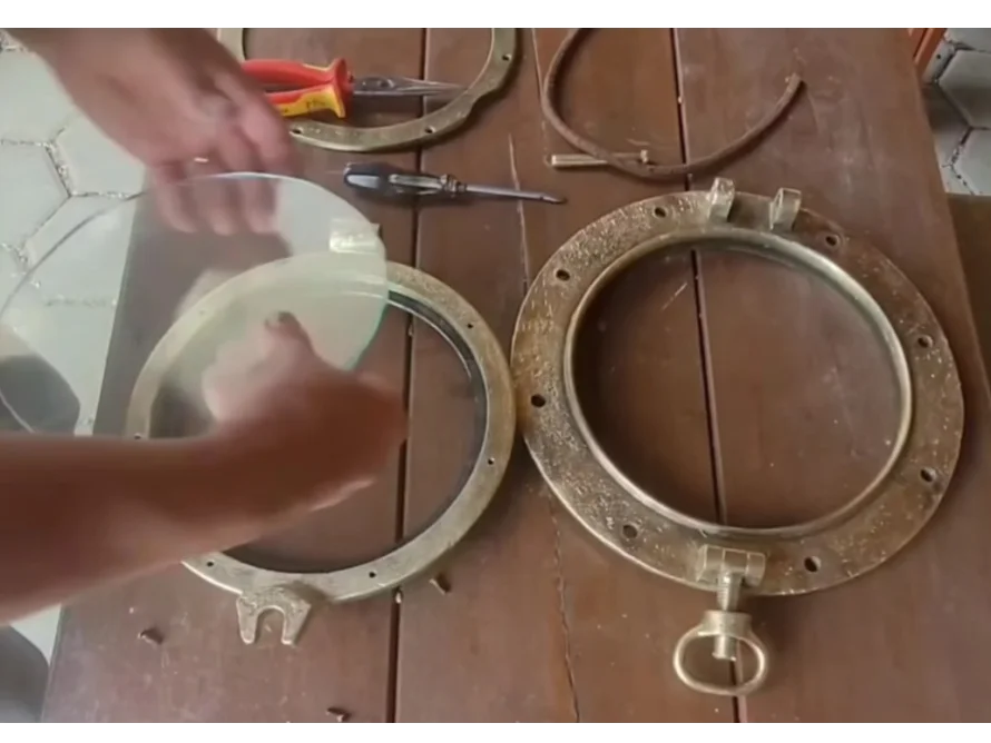 Person setzt Glas in Bullauge ein