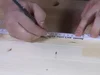 Person markiert Stelle auf Holz mit Bleistift