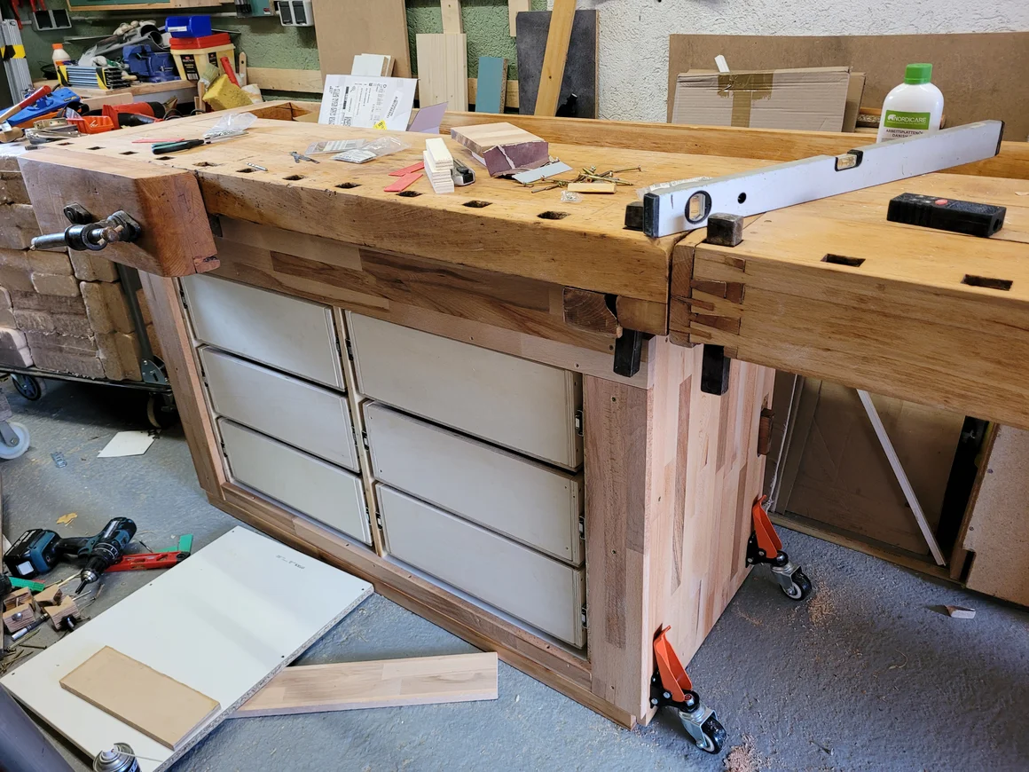 Eine massive Holzwerkbank mit Schubladen und Werkzeugen in einer Werkstatt.
