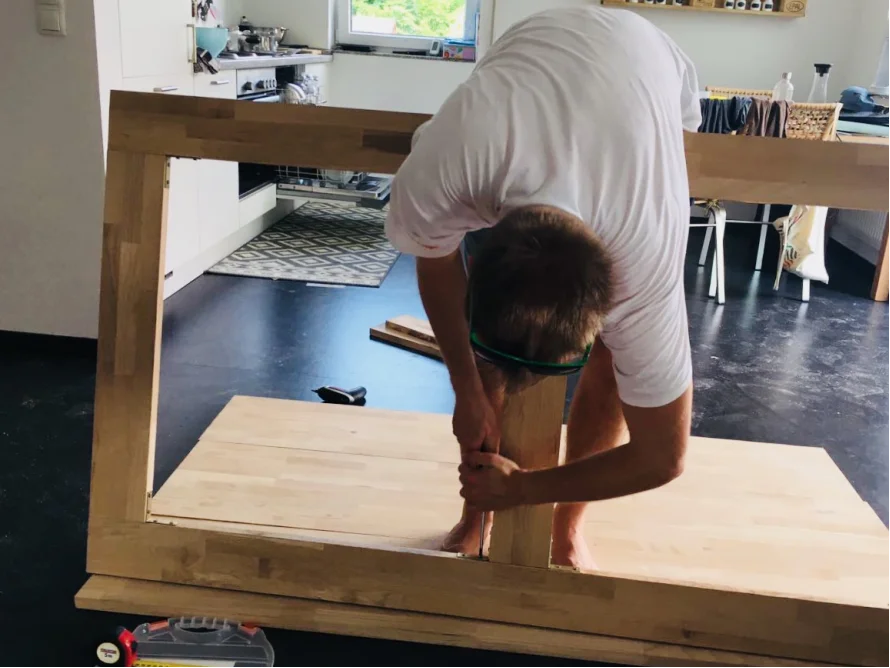 Person baut Holzrahmen mit Akkuschrauber