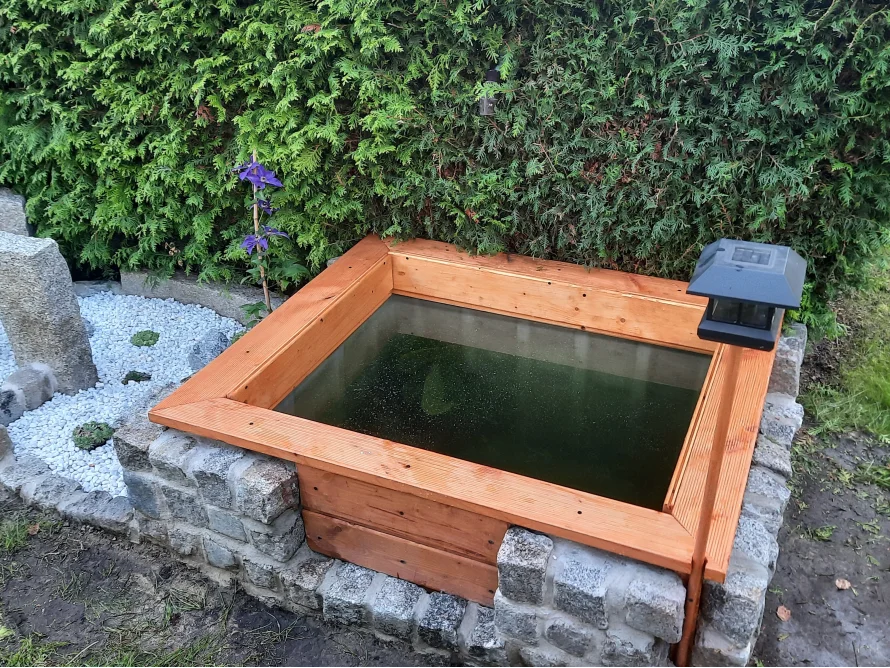 Kleiner Gartenteich mit Holzrahmen